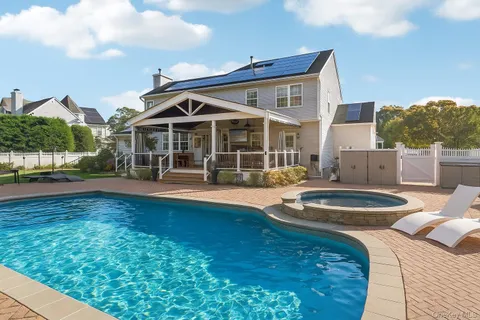 a view of a house with pool and chairs