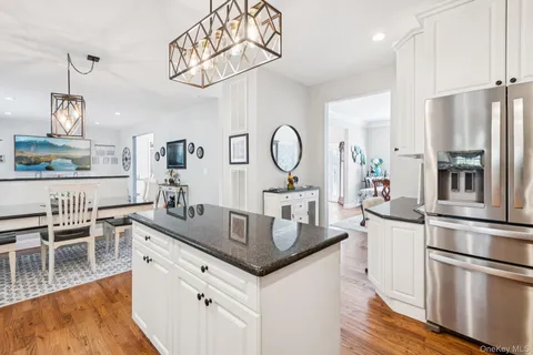 a kitchen with granite countertop a table chairs stove and wooden floor