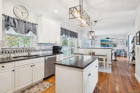 a kitchen with stainless steel appliances granite countertop a kitchen island a stove a table and chairs in it