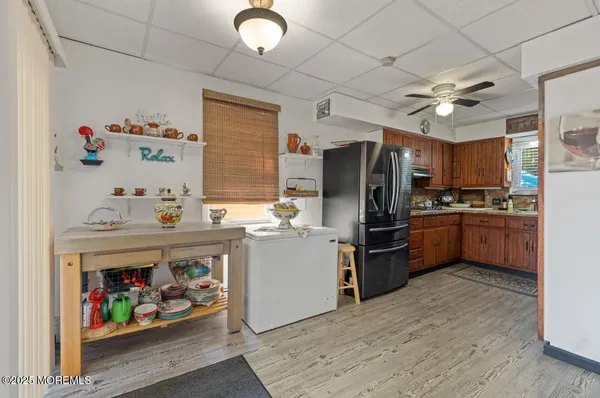 a kitchen with a refrigerator a microwave a sink and dishwasher with wooden floor