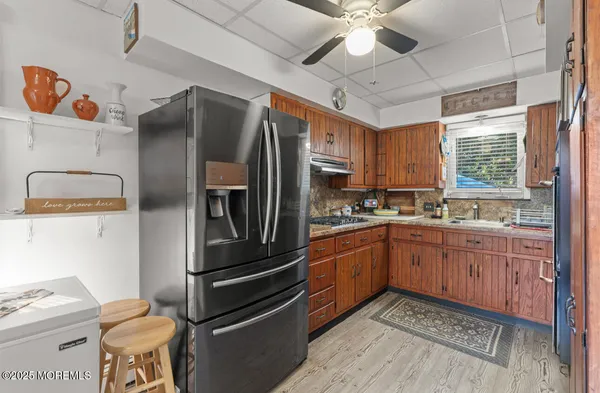 a kitchen with stainless steel appliances a refrigerator a stove a sink and chairs