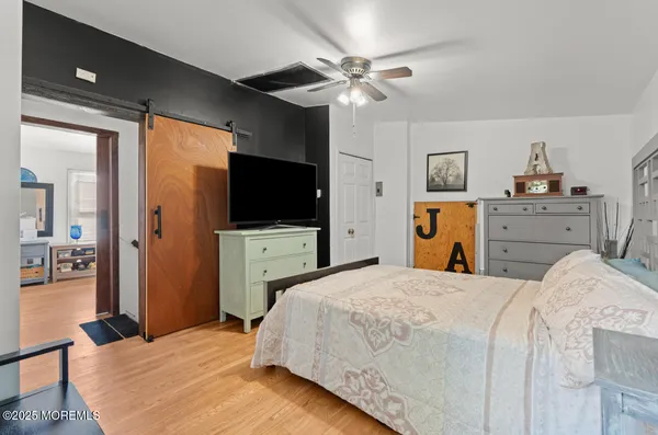 a bedroom with a bed and a flat tv screen on dresser