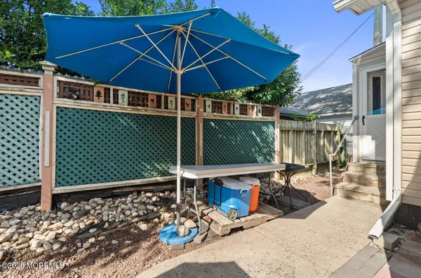 a view of a patio with table and chairs under an umbrella
