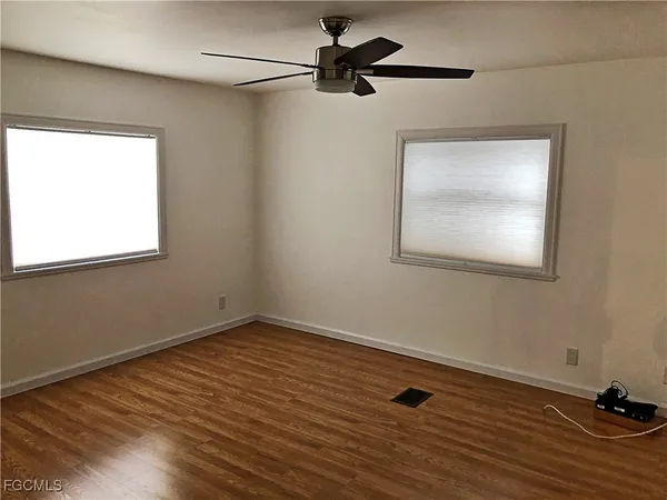 a view of room with hardwood floor and a ceiling fan