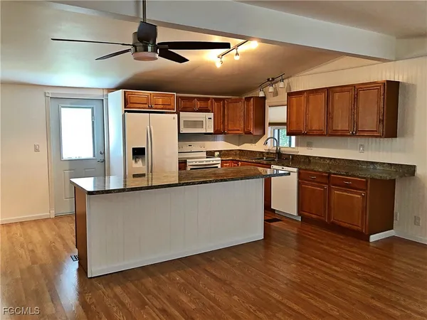 a kitchen with stainless steel appliances granite countertop a stove a sink and a microwave