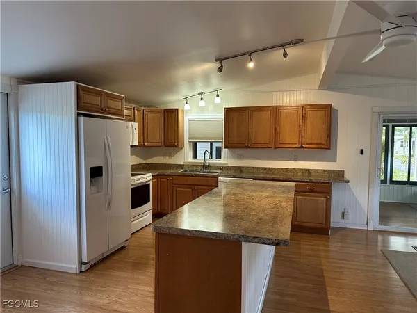 a kitchen with stainless steel appliances granite countertop a refrigerator a stove and a sink
