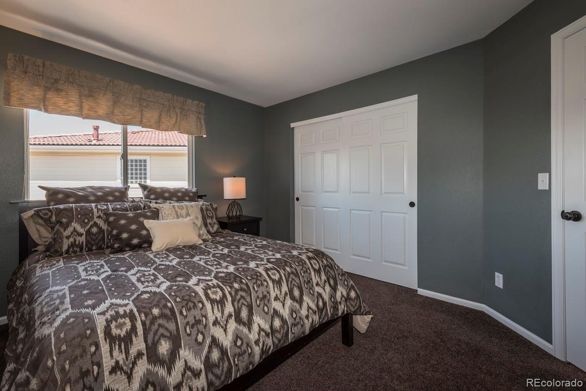 1279 Braewood Avenue Highlands Ranch, CO 80129 - Photo 4 of 20 a large bed sitting in a bedroom next to a window
