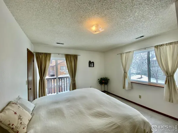 a bedroom with a bed and a large window
