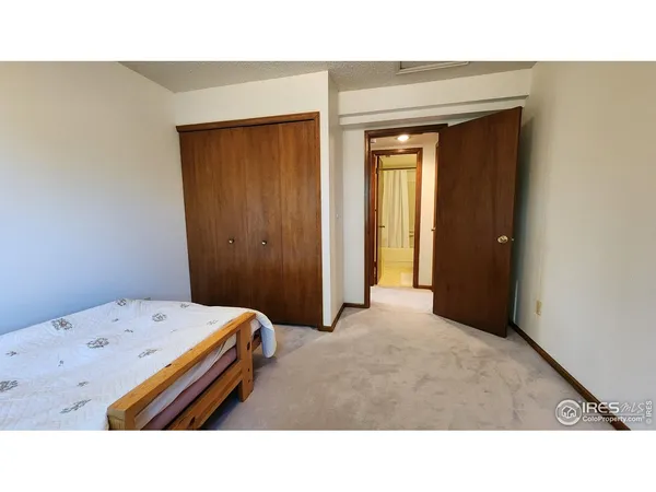 a room with a bed and a painting on the wall