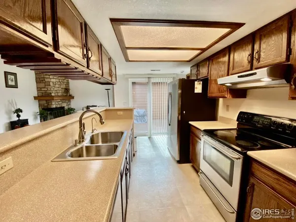 a kitchen with stainless steel appliances granite countertop a sink and wooden cabinets