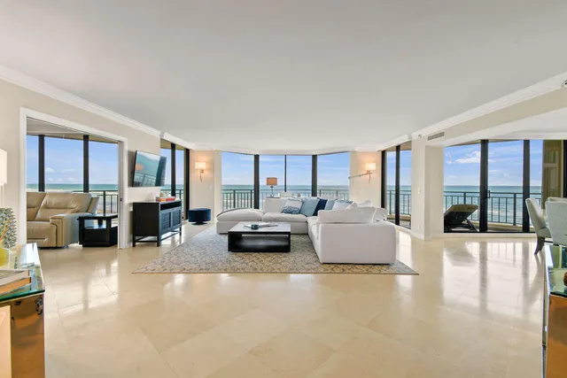 a living room with furniture large window and glass table