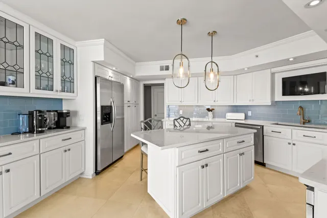 a kitchen with kitchen island granite countertop a sink a stove and cabinets