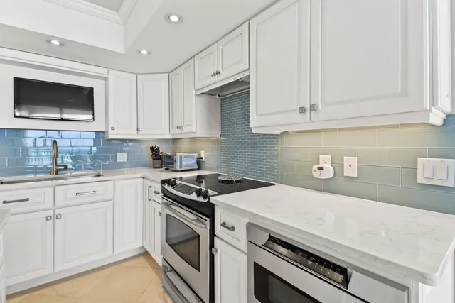 a kitchen with granite countertop white cabinets and white appliances