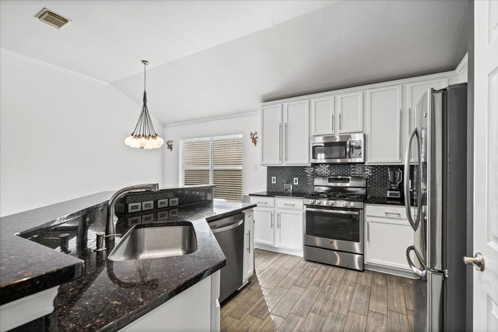 5948 Lomita Verde Circle Austin, TX 78749 - Photo 6 of 31 a kitchen with granite countertop a sink a stove and refrigerator