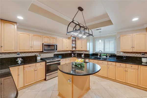 a kitchen with stainless steel appliances a sink a stove a counter space and cabinets
