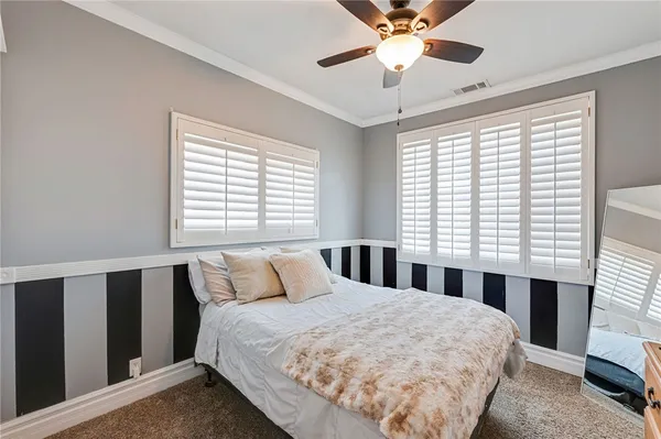 a bedroom with a bed and a large window