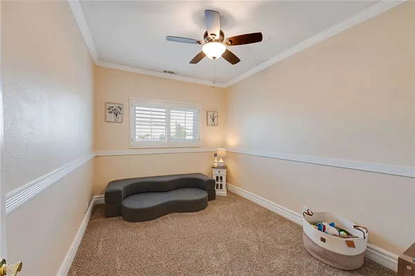 a bedroom with a bed and a chandelier fan
