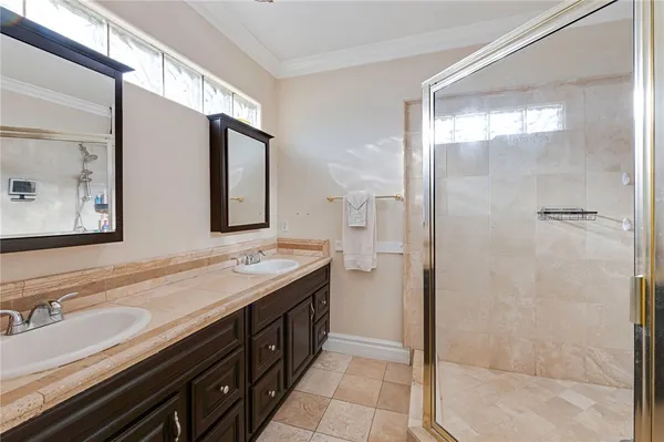 a bathroom with a double vanity sink mirror and shower