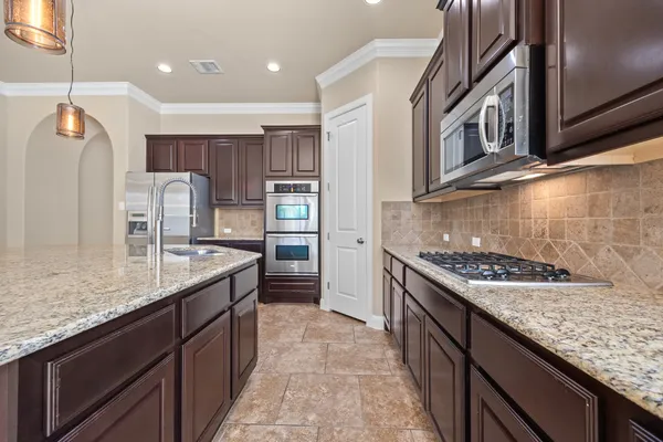 a kitchen with stainless steel appliances granite countertop a sink stove and refrigerator