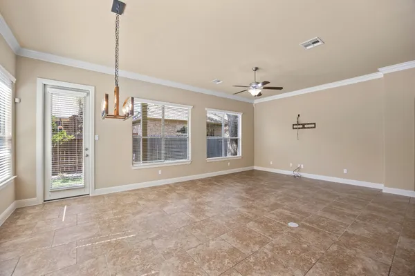 a view of a room with kitchen island stainless steel appliances cabinets and a chandelier