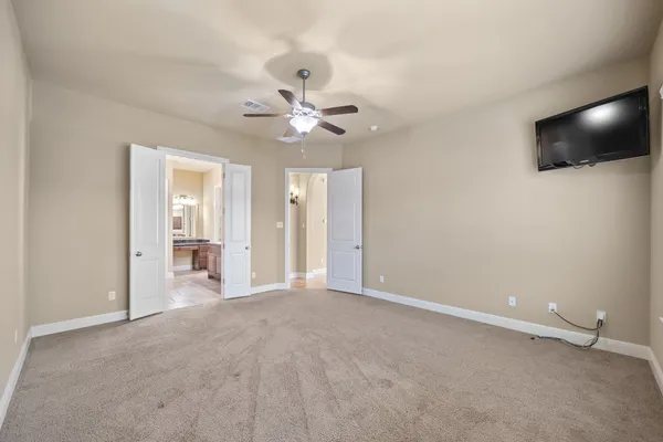 an empty room with windows fireplace and fan