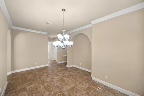 a view of an empty room with a chandelier fan