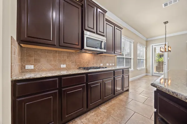 a kitchen with granite countertop stainless steel appliances and wooden cabinets