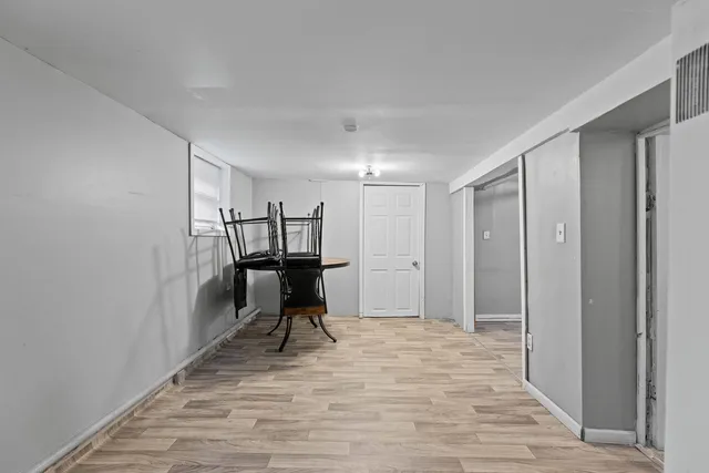 a view of a hallway with wooden floor and a cabinet