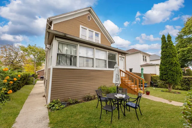 a backyard of a house with table and chairs