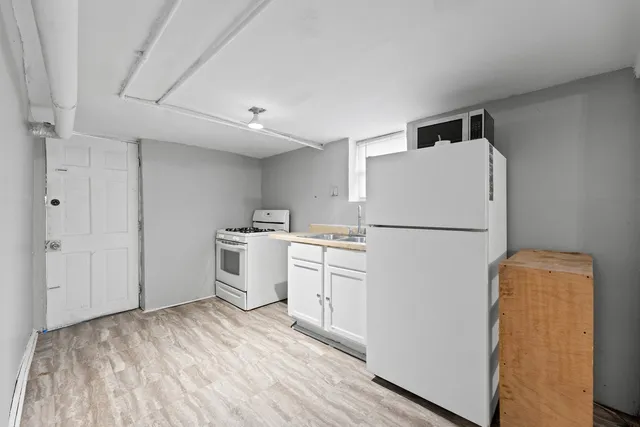 a kitchen with white cabinets and white appliances