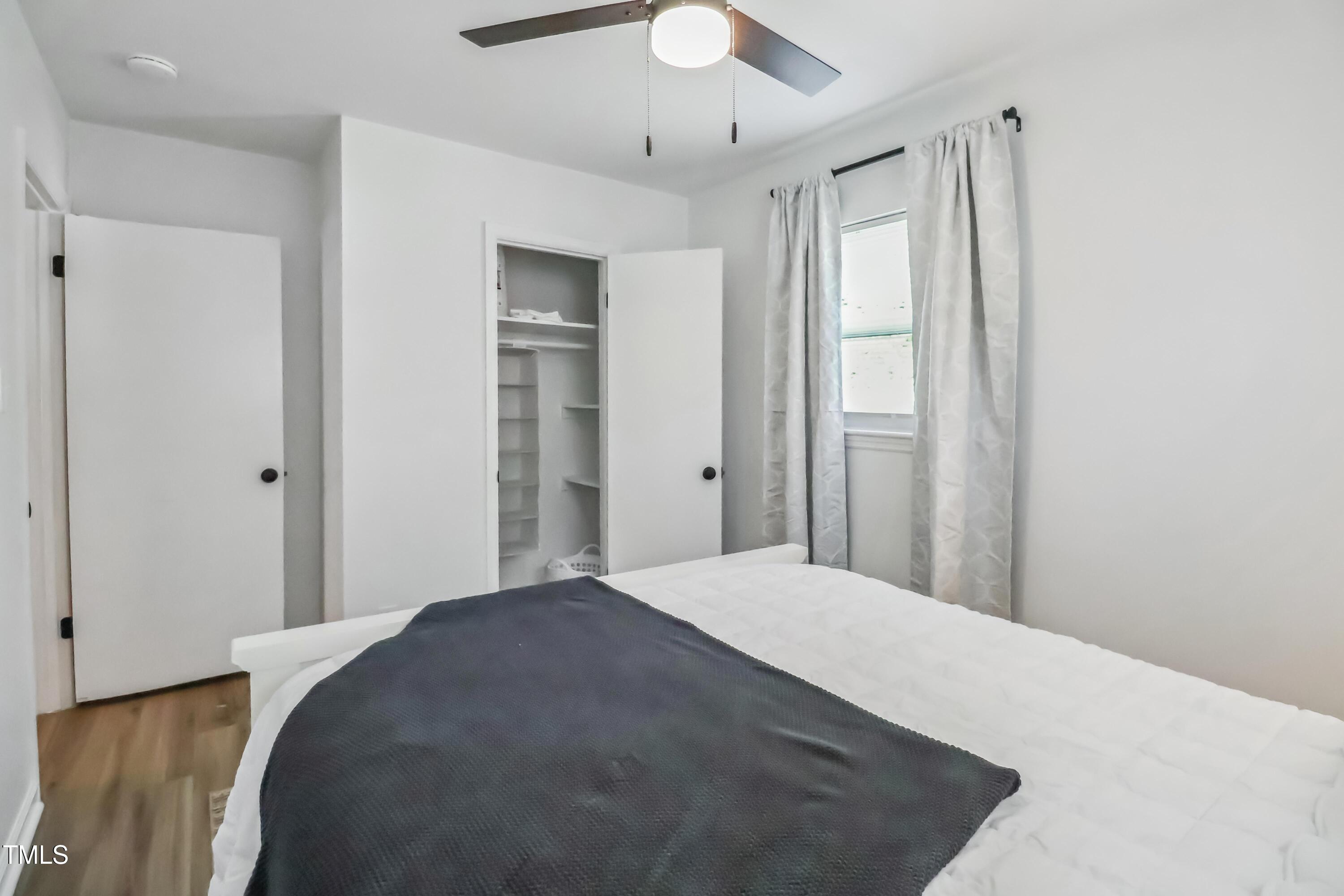 1300 South Street, Unit A Durham, NC 27707 - Photo 6 of 10 a bedroom with a bed and a chandelier