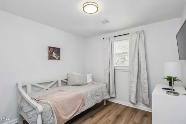 a bedroom with a bed and a potted plant