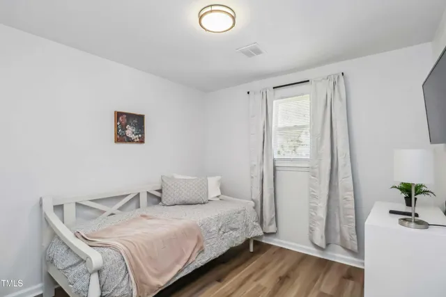 a bedroom with a bed and a potted plant
