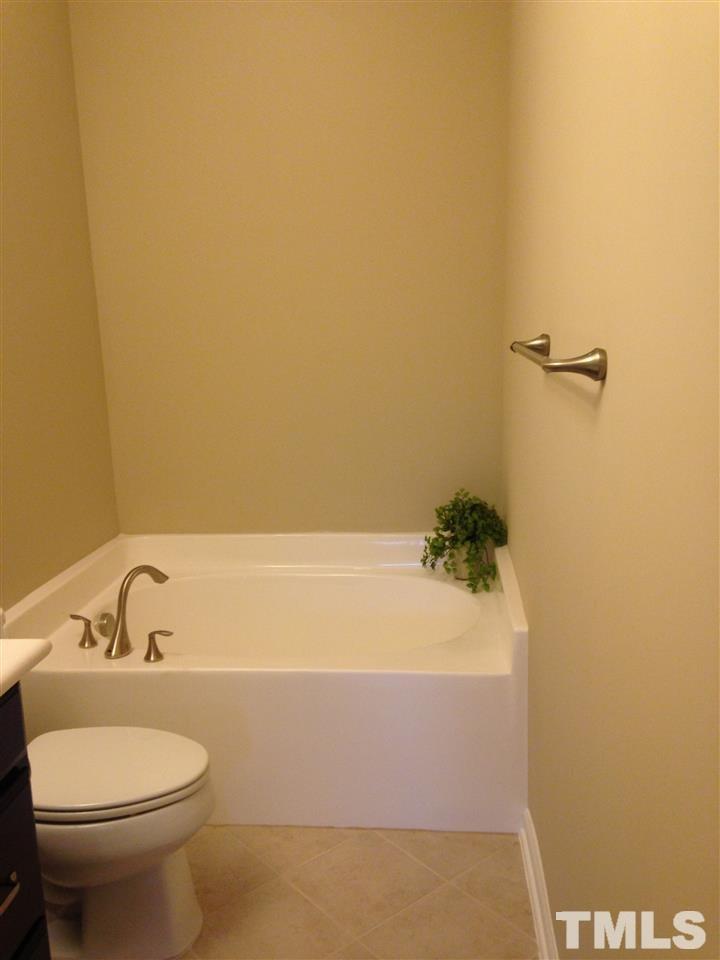682 Wickham Ridge Road, Unit 145 Apex, NC 27539 - Photo 17 of 25 a bathroom with a sink and bathtub