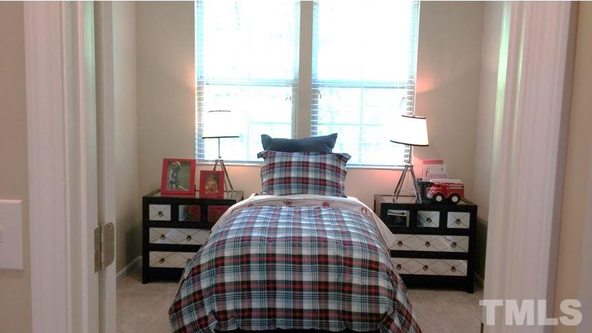 682 Wickham Ridge Road, Unit 145 Apex, NC 27539 - Photo 19 of 25 a bedroom with a bed and wooden floor