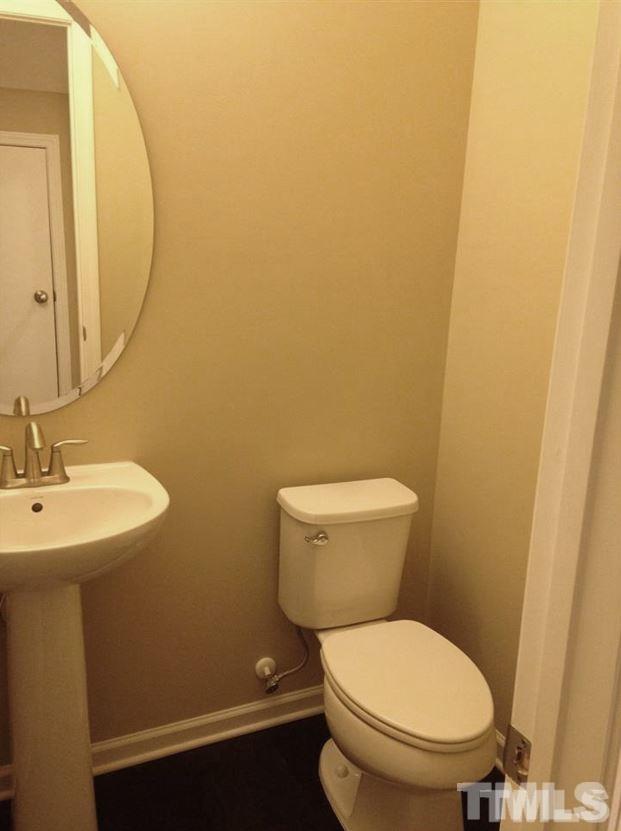 682 Wickham Ridge Road, Unit 145 Apex, NC 27539 - Photo 21 of 25 a white toilet sitting next to a bathroom sink