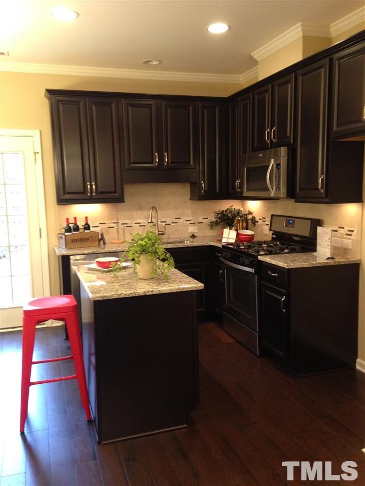 682 Wickham Ridge Road, Unit 145 Apex, NC 27539 - Photo 5 of 25 a kitchen with a sink and a stove