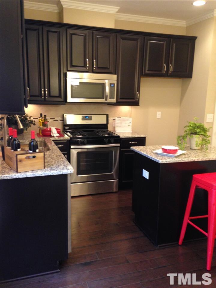 682 Wickham Ridge Road, Unit 145 Apex, NC 27539 - Photo 6 of 25 a kitchen with a sink and a stove