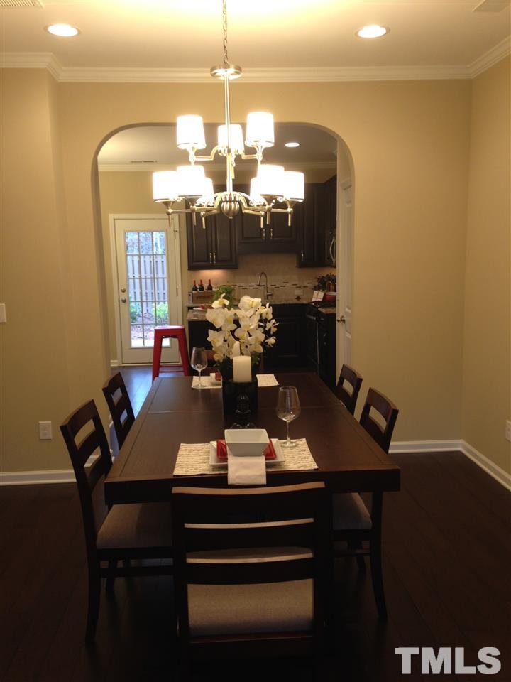 682 Wickham Ridge Road, Unit 145 Apex, NC 27539 - Photo 10 of 25 a view of a dining room with furniture and chandelier