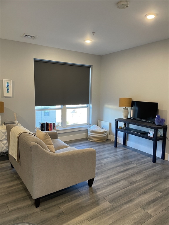 55 West Fifth Street, Unit 302 Boston, MA 02127 - Photo 5 of 7 a living room with furniture and a wooden floor