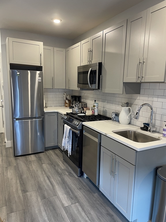 55 West Fifth Street, Unit 302 Boston, MA 02127 - Photo 6 of 7 a kitchen with wooden cabinets and stainless steel appliances