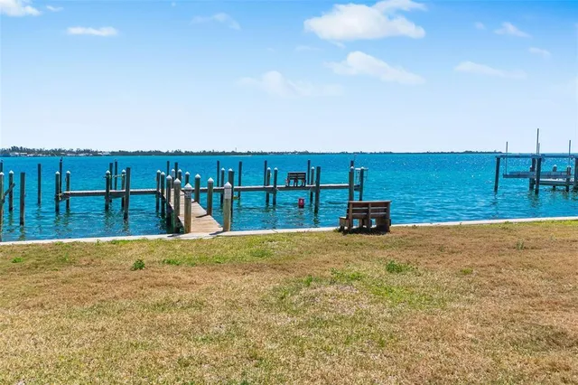 an aerial view of ocean and residential houses with outdoor space