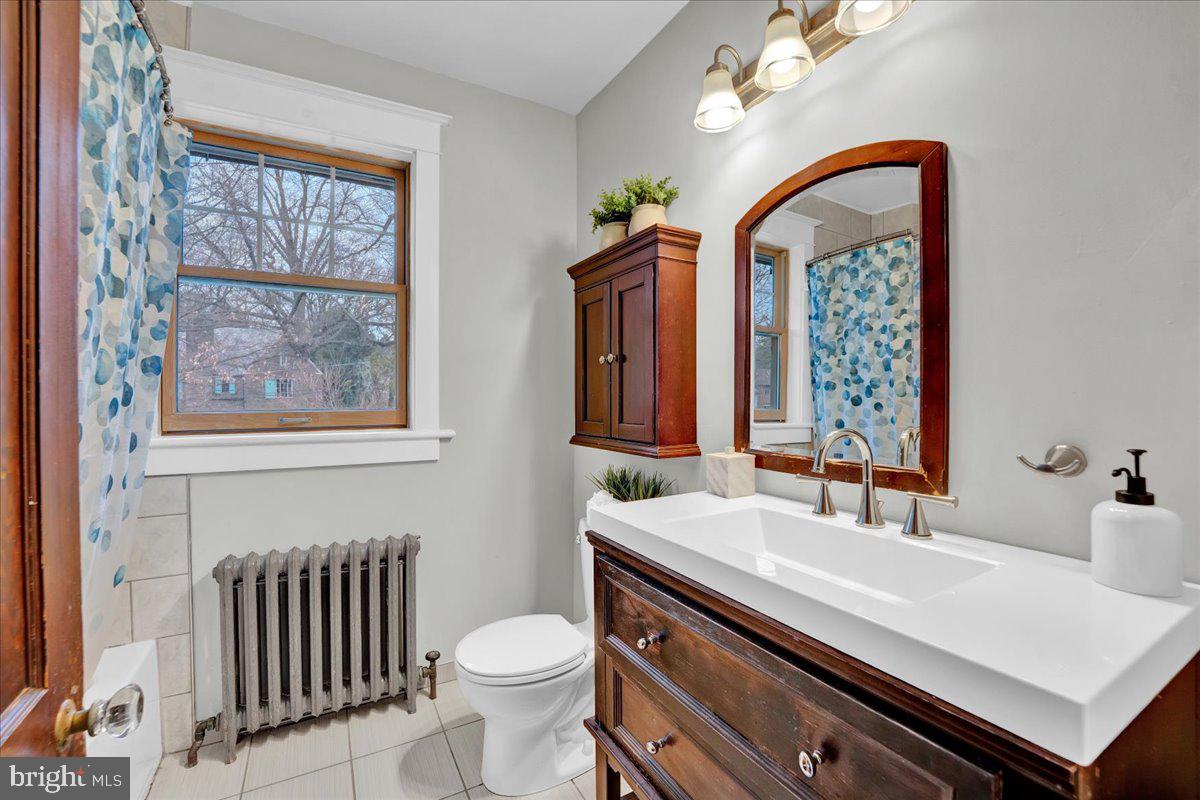 209 Hewett Road Wyncote, PA 19095 - Photo 30 of 36 a bathroom with a sink a toilet a mirror and a window