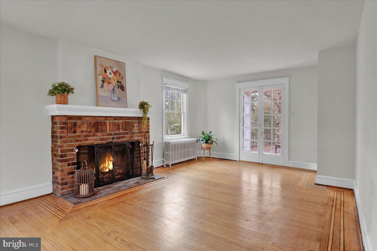 209 Hewett Road Wyncote, PA 19095 - Photo 6 of 36 a view of an empty room with wooden floor fireplace and a window