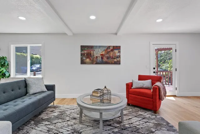 a living room with furniture a rug and a window
