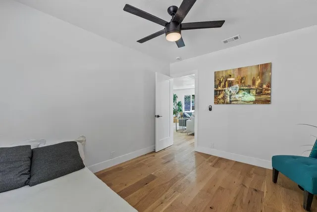 a view of a livingroom with wooden floor and a ceiling fan