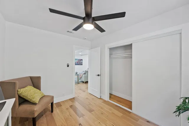 a view of a livingroom with wooden floor and a ceiling fan