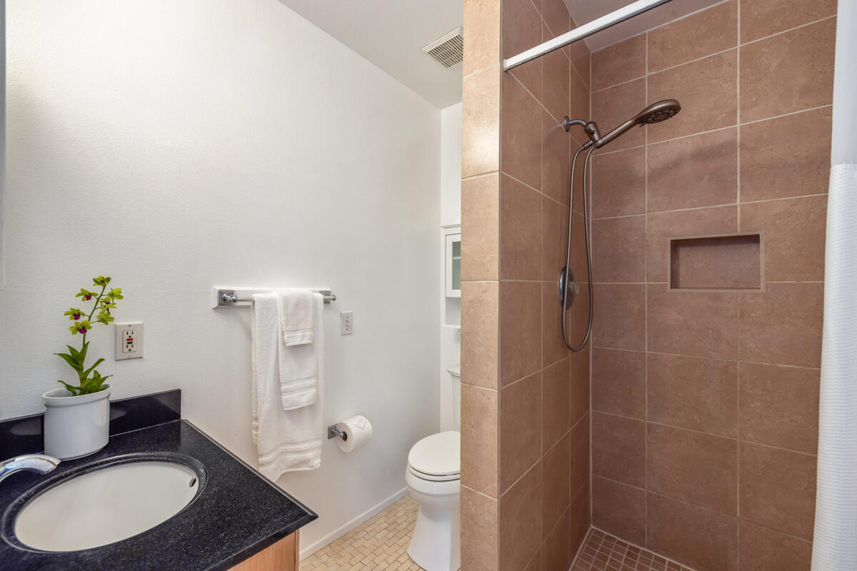 3307 D Hailima Road Koloa, HI 96756 - Photo 15 of 30 a bathroom with a granite countertop toilet a sink a shower and a mirror