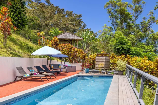 a backyard of a house with table and chairs under an umbrella