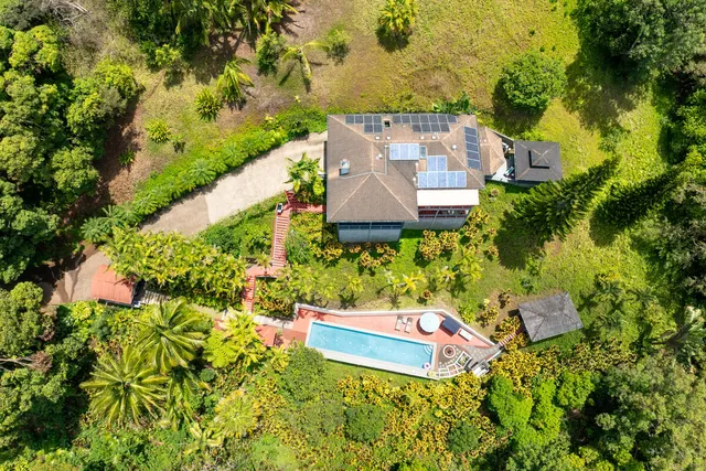 an aerial view of a house with swimming pool and garden